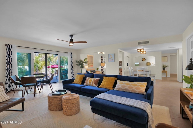 living room featuring light tile patterned floors, visible vents, and a ceiling fan