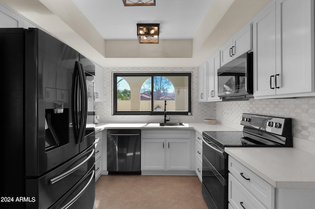 kitchen with black appliances, a sink, light countertops, and decorative backsplash