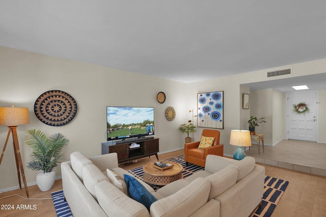 living area featuring light wood-style floors, baseboards, and visible vents