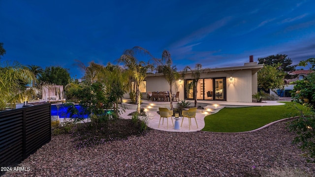 back of house featuring an outdoor pool, french doors, a yard, and a patio