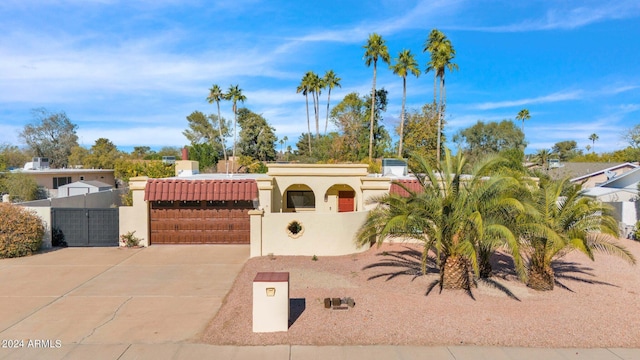 view of front facade featuring a fenced front yard, a gate, a tile roof, and stucco siding