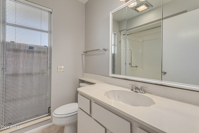 bathroom featuring toilet, vanity, tile patterned floors, and walk in shower