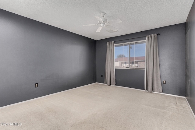 carpeted empty room with ceiling fan and a textured ceiling