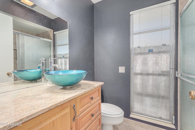 bathroom with toilet, vanity, tile patterned floors, and walk in shower