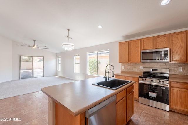 41767 W Somerset Dr, Maricopa, AZ 85138 - kitchen featuring appliances with stainless steel finishes, light colored carpet, tasteful backsplash, pendant lighting, and an island with sink
