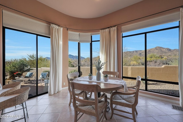 sunroom featuring a mountain view and visible vents