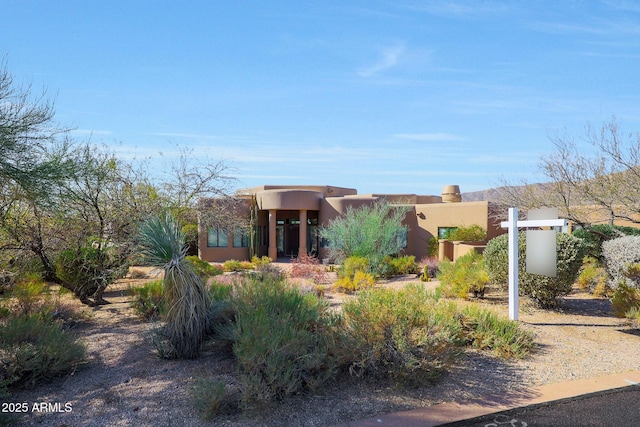 pueblo revival-style home featuring stucco siding