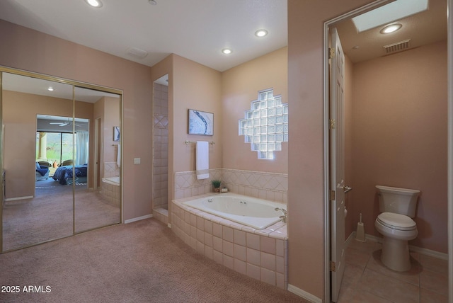 bathroom with baseboards, visible vents, toilet, a garden tub, and tile patterned flooring