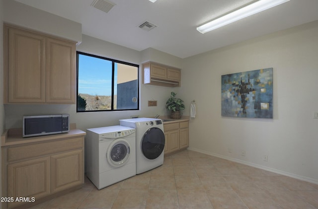 washroom featuring visible vents, separate washer and dryer, a sink, and light tile patterned flooring