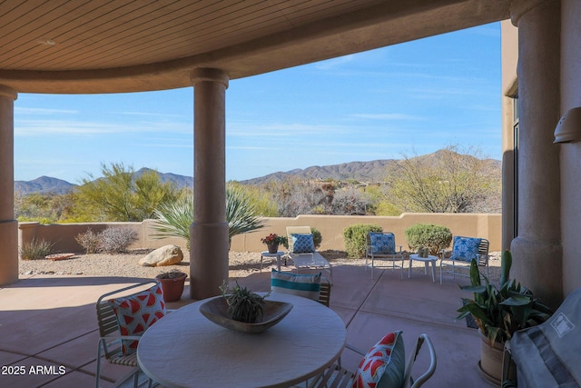 view of patio / terrace featuring outdoor dining area, a fenced backyard, and a mountain view