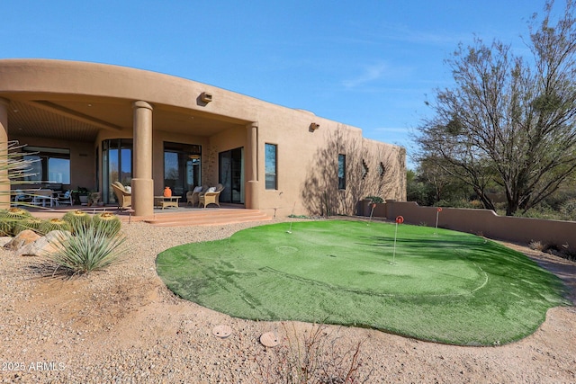 rear view of house featuring a patio area and stucco siding