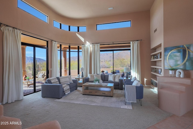 carpeted living area featuring a towering ceiling, tile patterned flooring, and a wealth of natural light