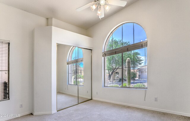 unfurnished bedroom featuring ceiling fan, a closet, and light carpet