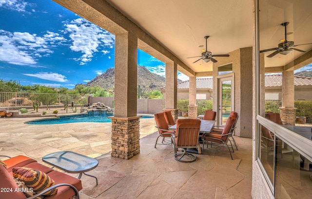 view of patio featuring a fenced in pool, a mountain view, and ceiling fan