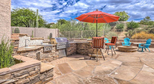 view of patio with area for grilling, an outdoor fire pit, grilling area, and sink