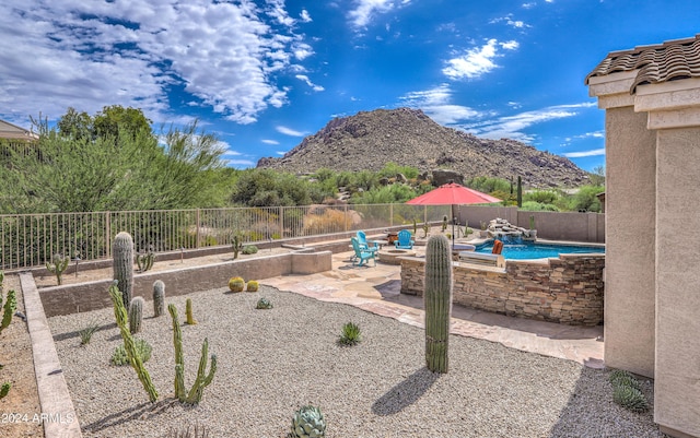 exterior space with a mountain view, a patio, and a fenced in pool