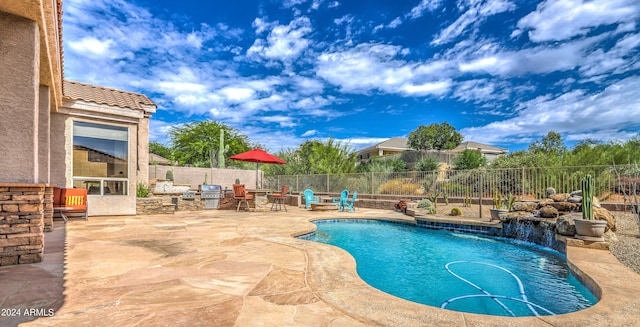 view of pool featuring a patio, pool water feature, and grilling area