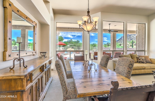 carpeted dining area with an inviting chandelier