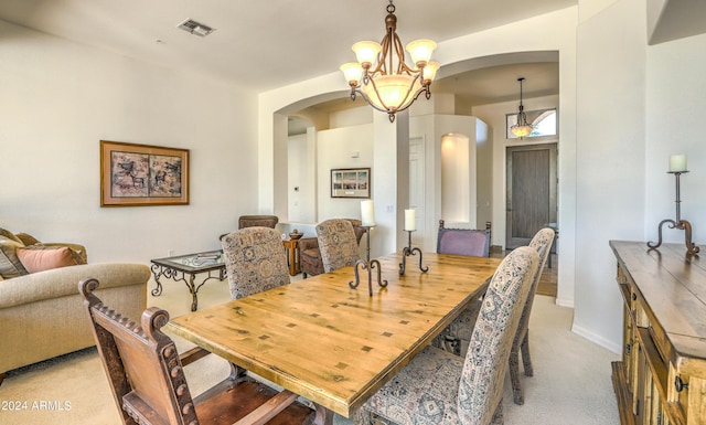 dining space with light colored carpet and a notable chandelier