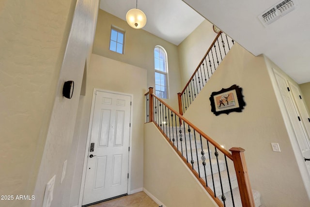 tiled entrance foyer featuring a high ceiling