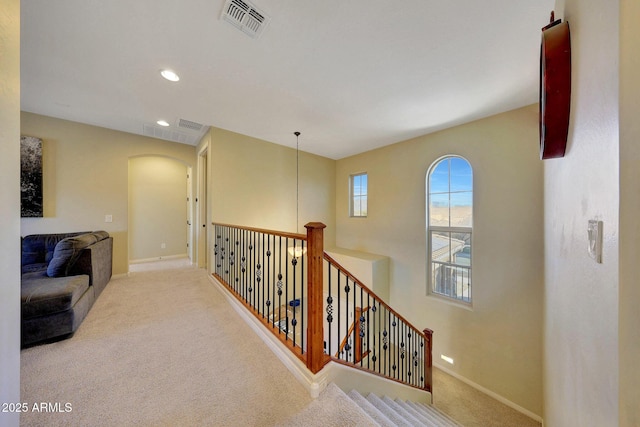 hall with light colored carpet