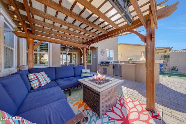 view of patio / terrace with a grill, a pergola, an outdoor living space with a fire pit, and exterior kitchen