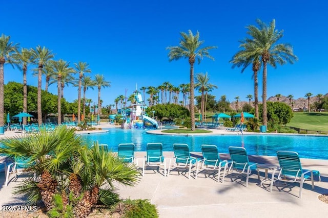 view of swimming pool with a playground, a water slide, and a patio area