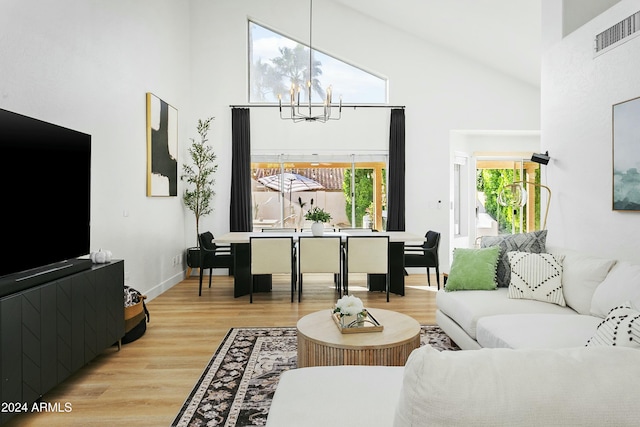 living room with a high ceiling, a notable chandelier, and wood-type flooring