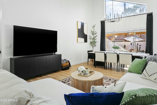 living room featuring wood-type flooring and an inviting chandelier