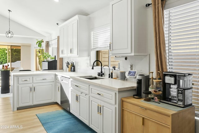 kitchen with kitchen peninsula, pendant lighting, dishwasher, white cabinets, and lofted ceiling