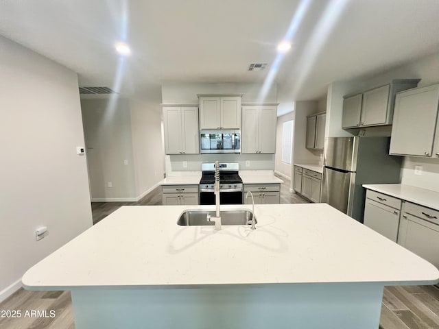 kitchen with wood finished floors, visible vents, and appliances with stainless steel finishes