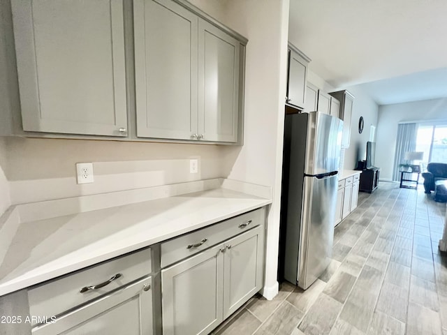 kitchen featuring freestanding refrigerator, light countertops, and gray cabinets