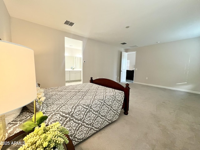 bedroom with carpet flooring, ensuite bathroom, visible vents, and baseboards