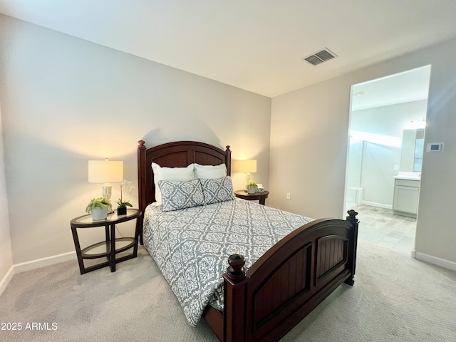 bedroom with baseboards, ensuite bathroom, visible vents, and light colored carpet