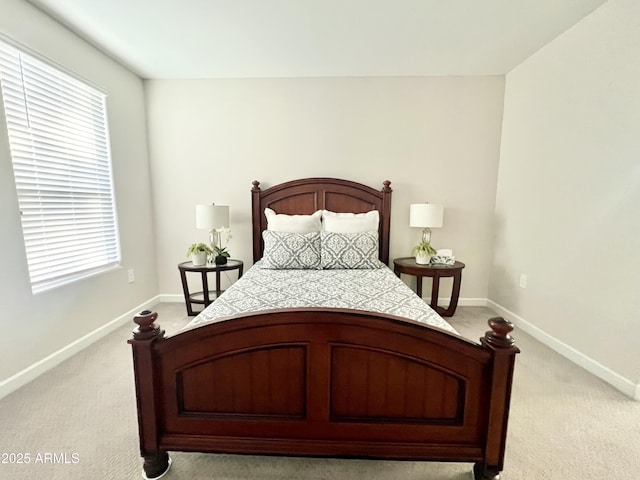 bedroom with baseboards, multiple windows, and light carpet
