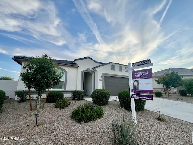 view of front of home featuring stucco siding, driveway, and a garage