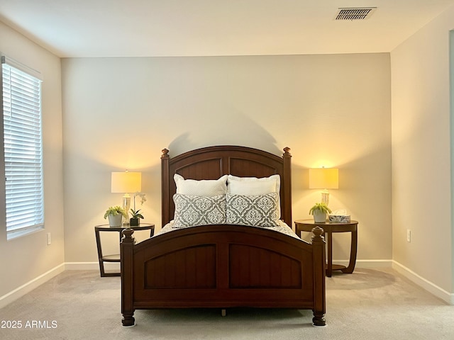 bedroom with multiple windows, visible vents, baseboards, and light carpet