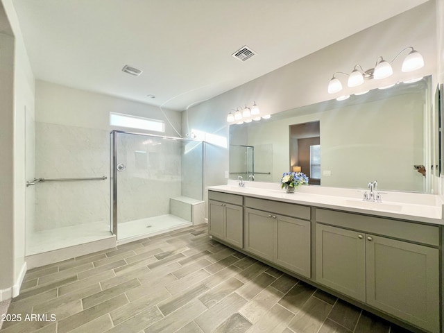 full bathroom featuring walk in shower, visible vents, a sink, double vanity, and wood finished floors
