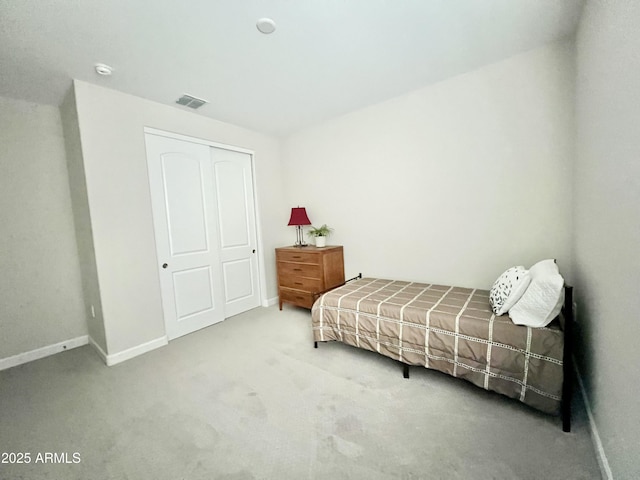 bedroom featuring carpet flooring, a closet, visible vents, and baseboards