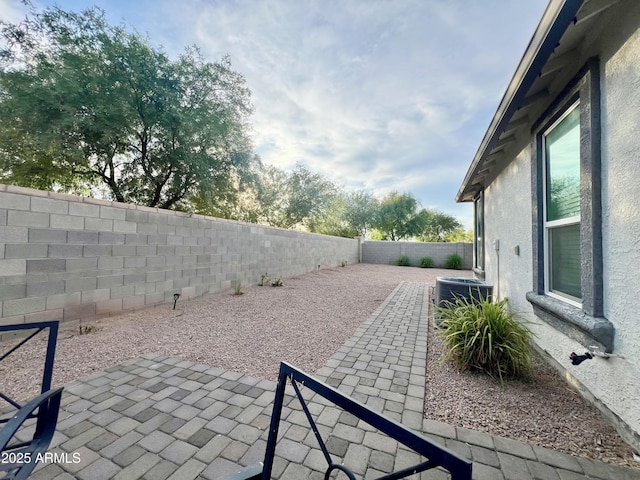 view of patio / terrace with central air condition unit and a fenced backyard