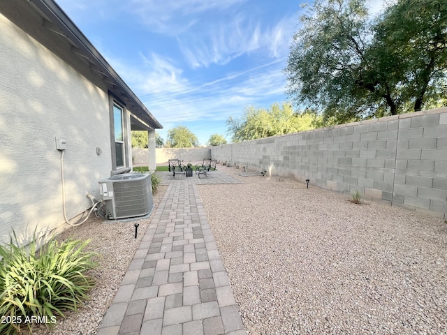 view of yard featuring central AC unit, a patio area, and a fenced backyard