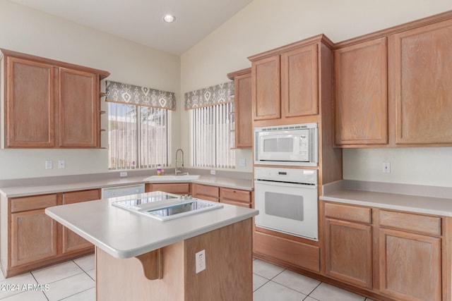 kitchen featuring white appliances, light tile patterned floors, lofted ceiling, a center island, and sink