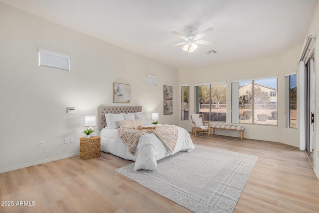 bedroom featuring light wood-style floors, visible vents, baseboards, and a ceiling fan