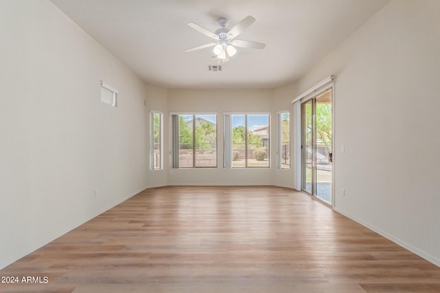 empty room with ceiling fan and light hardwood / wood-style flooring