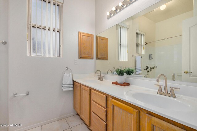 bathroom featuring double vanity, baseboards, a sink, and tile patterned floors