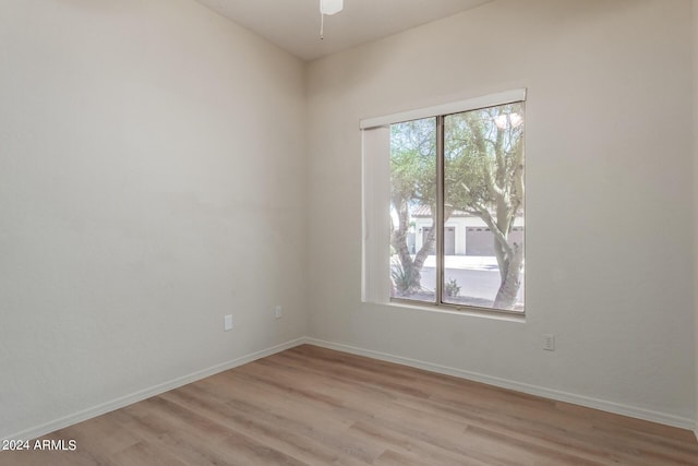 unfurnished room featuring ceiling fan, light wood-type flooring, and baseboards