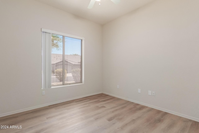 unfurnished room featuring baseboards, light wood-style flooring, and a ceiling fan