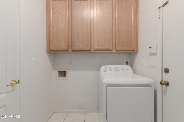 washroom featuring cabinets, washer / clothes dryer, and light tile patterned floors