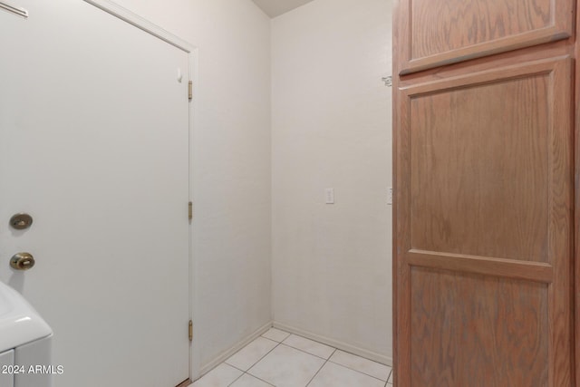 laundry area featuring laundry area, baseboards, and light tile patterned floors