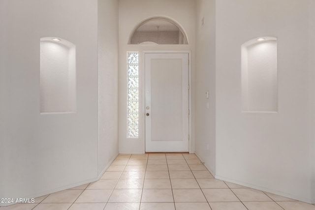 foyer featuring light tile patterned flooring and a healthy amount of sunlight